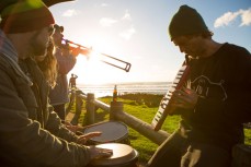 Musicians play music in the afternoon light at Manu Bay, Raglan, Waikato, New Zealand. 