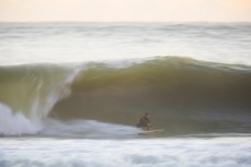 A surfer bottom turns on a solid wave at Manu Bay, Raglan, Waikato, New Zealand. 