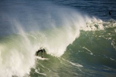 Tom Bracegirdle rides a tube in powerful surf at Blackhead Beach, Dunedin, New Zealand. 