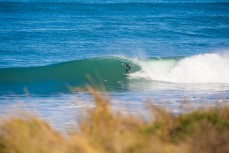 A surfer steps on the gas in a clean winter swell at St Kilda beach, Dunedin, New Zealand. 