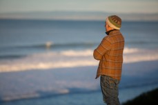 Artist Simon Kaan checks the surf at St Kilda, Dunedin, New Zealand. 