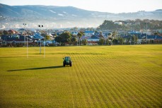 A tractor and driver prepare the field for rugby at Pitrates, St Kilda, Dunedin, New Zealand. 