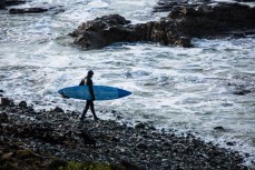 Lewellyn prepares to paddle out into big waves at Papatowai in the Catlins, New Zealand. 