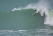 Tom Bracegirdle takes off on a huge wave after paddling in at Papatowai in the Catlins, New Zealand. 