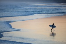 A surfer heads home at Blackhead Beach, Dunedin, New Zealand. 