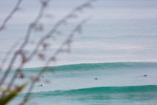 Surfers chase small peaks at Blackhead Beach, Dunedin, New Zealand. 