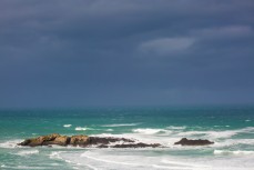 Storm swell surges into Bird Island at Smaills Beach, Dunedin, New Zealand. 