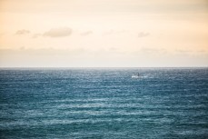 A fishing boat battles northerly winds at St Clair Beach, Dunedin, New Zealand. 