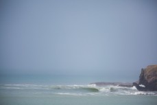 A wave peels down a headland, Dunedin, New Zealand. 
