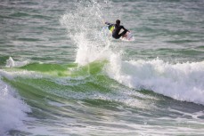 A surfer airs on a wave at Manu Bay, Raglan, New Zealand. 
