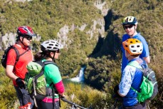 A group of riders pause to take in the view of the Tieke Falls on the Waihaha River during a ride of the Waihaha to Waihora section of the Great Lake Trail, Taupo, New Zealand.