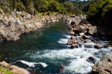 Glenn Cullen and Naomi Madeiros make their way along a section of the Hauraki Rail Trail where it cuts through Karangahake Gorge, Coromandel, New Zealand.