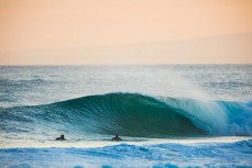 Surfers paddle back to the peak at dusk at St Kilda Beach, Dunedin, New Zealand. 