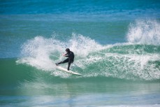 A surfer jams the tail on a wave on Otago Peninsula, Dunedin, New Zealand. 
