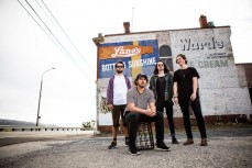 Bandmembers of Dunedin band Ragged at the Tiger Tea wall near Ravensbourne, Dunedin, New Zealand. 