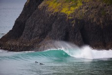 Clean small waves peel down a rock wall at Second Beach, St Clair, Dunedin, New Zealand. 