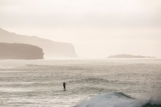 A paddleboarder chases peaks along St Clair Beach at dawn, Dunedin, New Zealand. 