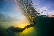 A surfer duckdives beneath a wave at St Kilda Beach, Dunedin, New Zealand. 