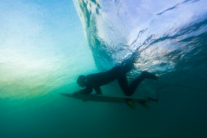 A surfer duckdives beneath a wave at St Kilda Beach, Dunedin, New Zealand. 
