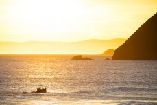 Surf lifesavers head into the sunset at St Kilda Beach, Dunedin, New Zealand. 