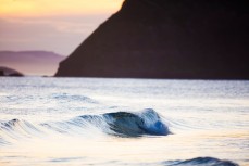 A small, glassy wave breaks on dusk at St Kilda Beach, Dunedin, New Zealand. 