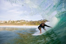 A surfer ducks under the lip at Bungan Beach on the Northern beaches of Sydney, NSW, Australia. 