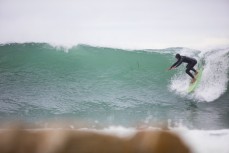 Tane drives into a wave on the North Coast, Dunedin, New Zealand. 