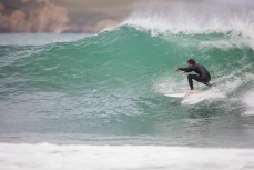 A surfer ducks for the section on the North Coast, Dunedin, New Zealand. 