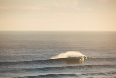 An outer bank at St Kilda unloads in the golden light of a late evening session, Dunedin, New Zealand. 