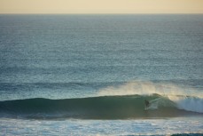 A surfer stands for a barrel at St Kilda Beach, Dunedin, New Zealand. 