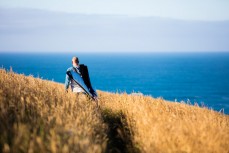 Che Bliss walking in search of waves at a remote surf break in the Catlins, Southland, New Zealand. 