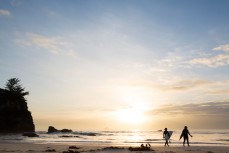 Couple of surfer girls head out for a dawnie at Brighton near Dunedin, Otago, New Zealand. 