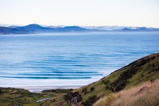 Swell lines pour into a beach on the North Coast of Dunedin, New Zealand. 