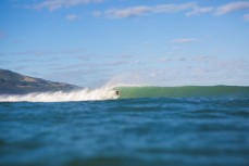 Matt Scorringe picks up a set wave at the bar at Whaingaroa Harbour, Raglan, New Zealand. 