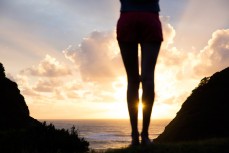 Sunset between the legs of Rose Halfpenny at the beautiful Bethells Beach, Auckland, New Zealand. 