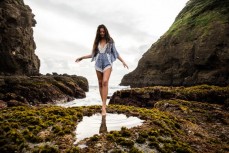 Sofia Levi dips a tow in a rockpool during the Canon Collective Beach Culture Workshop at the beautiful Bethells Beach, Auckland, New Zealand. 