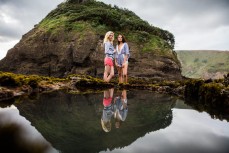 Sofia Levi (right) and Rose Halfpenny are reflected in a still rockpool during the Canon Collective Beach Culture Workshop at the beautiful Bethells Beach, Auckland, New Zealand. 