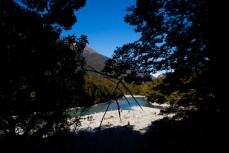 Rock cairns and tourists enjoy a clear crisp autumn day at Blue Pools near Makarora, Wanaka, New Zealand. 