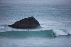 A surfer bottom turns on a nice wave at Second Beach, Dunedin, New Zealand. 