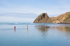Taya (10) and Rewa (8) go exploring in a calm rockpool at a remote beach on Otago Peninsula, Dunedin, New Zealand. 