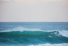 A surfer rides a wave at St Clair Beach, Dunedin, New Zealand. 