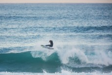 A surfer rides a wave at St Clair Beach, Dunedin, New Zealand. 