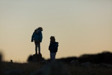 The assistants Rewa and Keo catching lizards above Aramoana on the North Coast, Dunedin, New Zealand. 