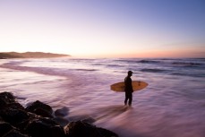 Hamish waits for the sets before paddling out for the morning at St Clair Beach, Dunedin, New Zealand. 
