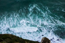 A wave breaks beneath the cliffs of St Clair, Dunedin, New Zealand. 
