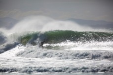 Surfers chase the peak during a solid swell on the north coast, Dunedin, New Zealand. 