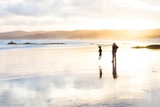 Rewa (9) and Remi play in dusk light at a beach near Birghton, Dunedin, New Zealand. 