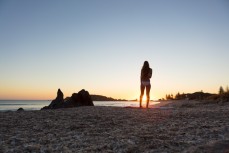 Kristin relaxes in the sunshine at the beach, Mount Maunganui, Bay of Plenty, New Zealand. 