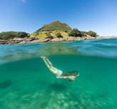Kristin relaxes in the sunshine at the beach, Mount Maunganui, Bay of Plenty, New Zealand. 