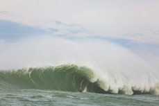 Delta standing near the base of a monster wave during a storm swell in the Southern Catlins, Southland, New Zealand. 